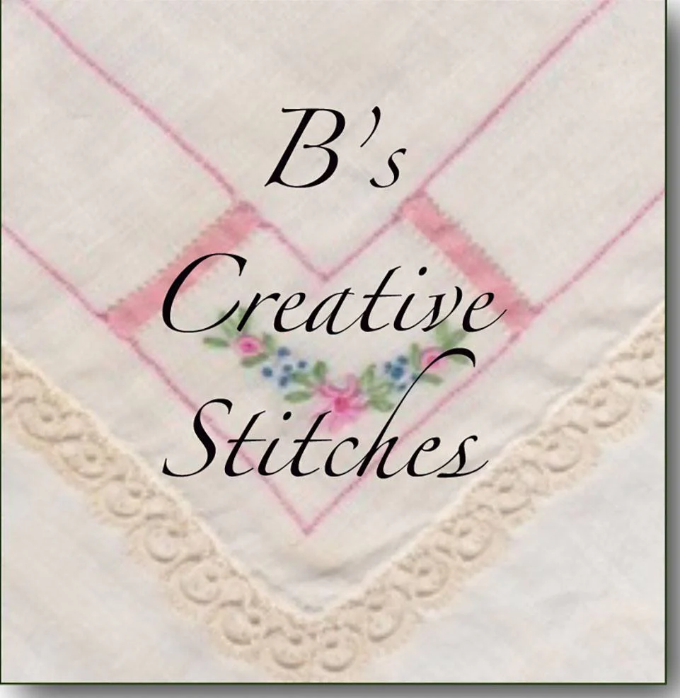 "B’s Creative Stitches" text over a delicate embroidered cloth with lace trim and floral accents.