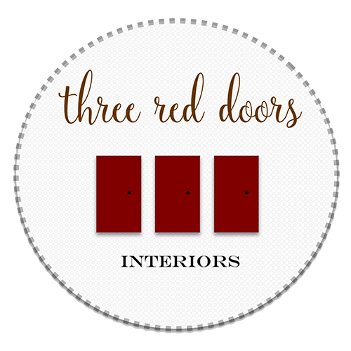 Logo for "Three Red Doors Interiors" featuring three red doors on a circular white background with elegant text.